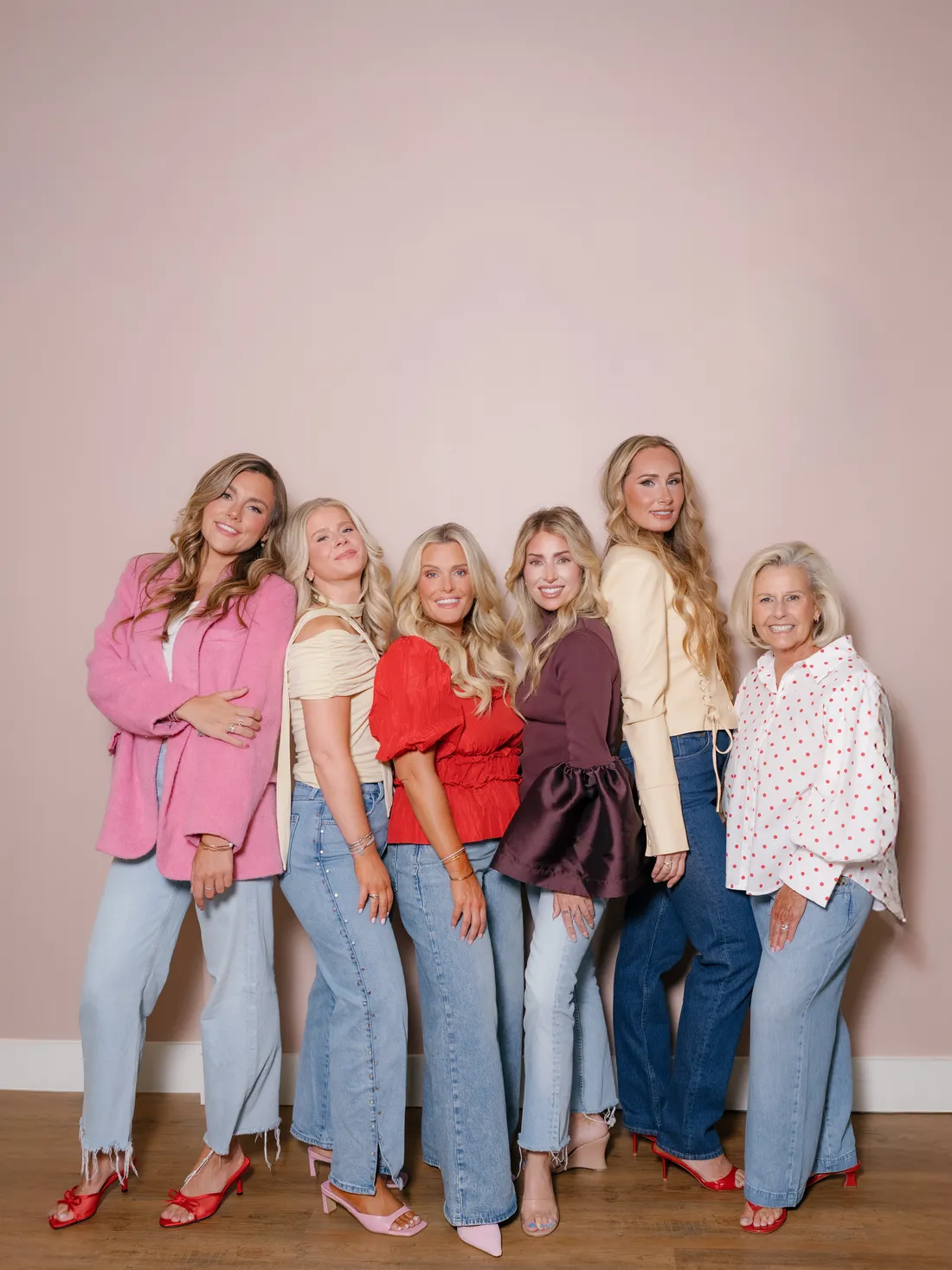 Poppy Planning's planners standing together against a blush studio wall