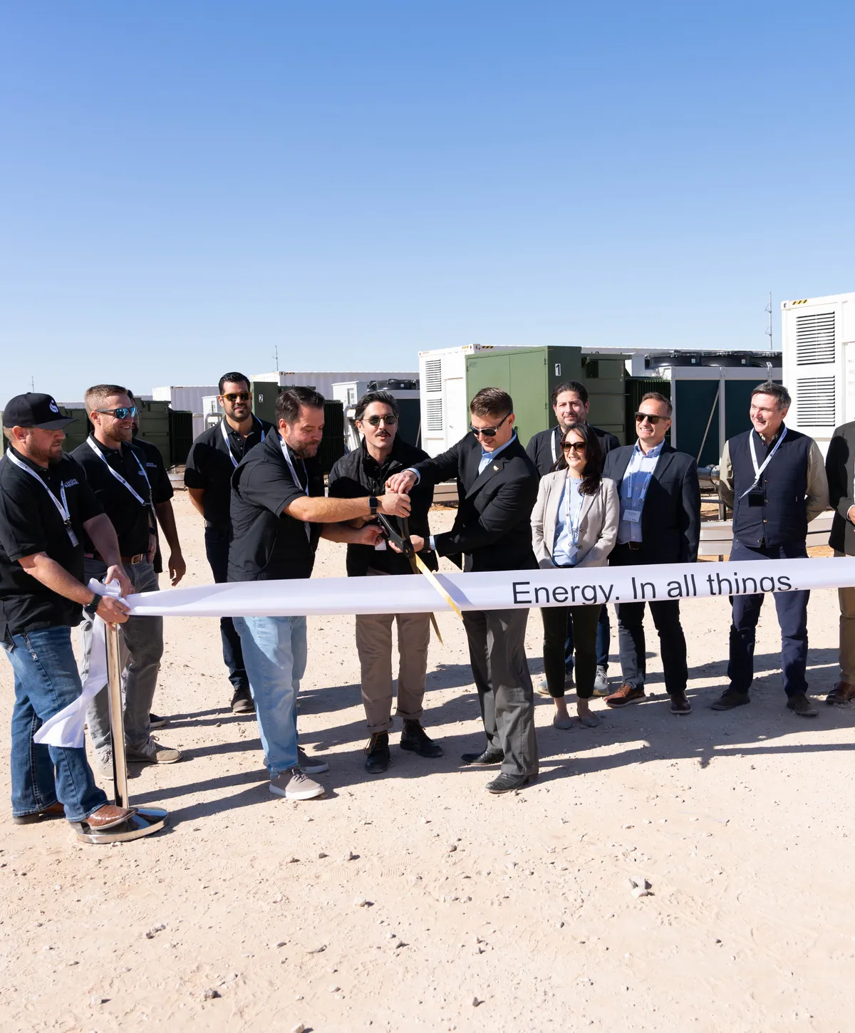 A ribbon cutting at an outdoor corporate milestone event
