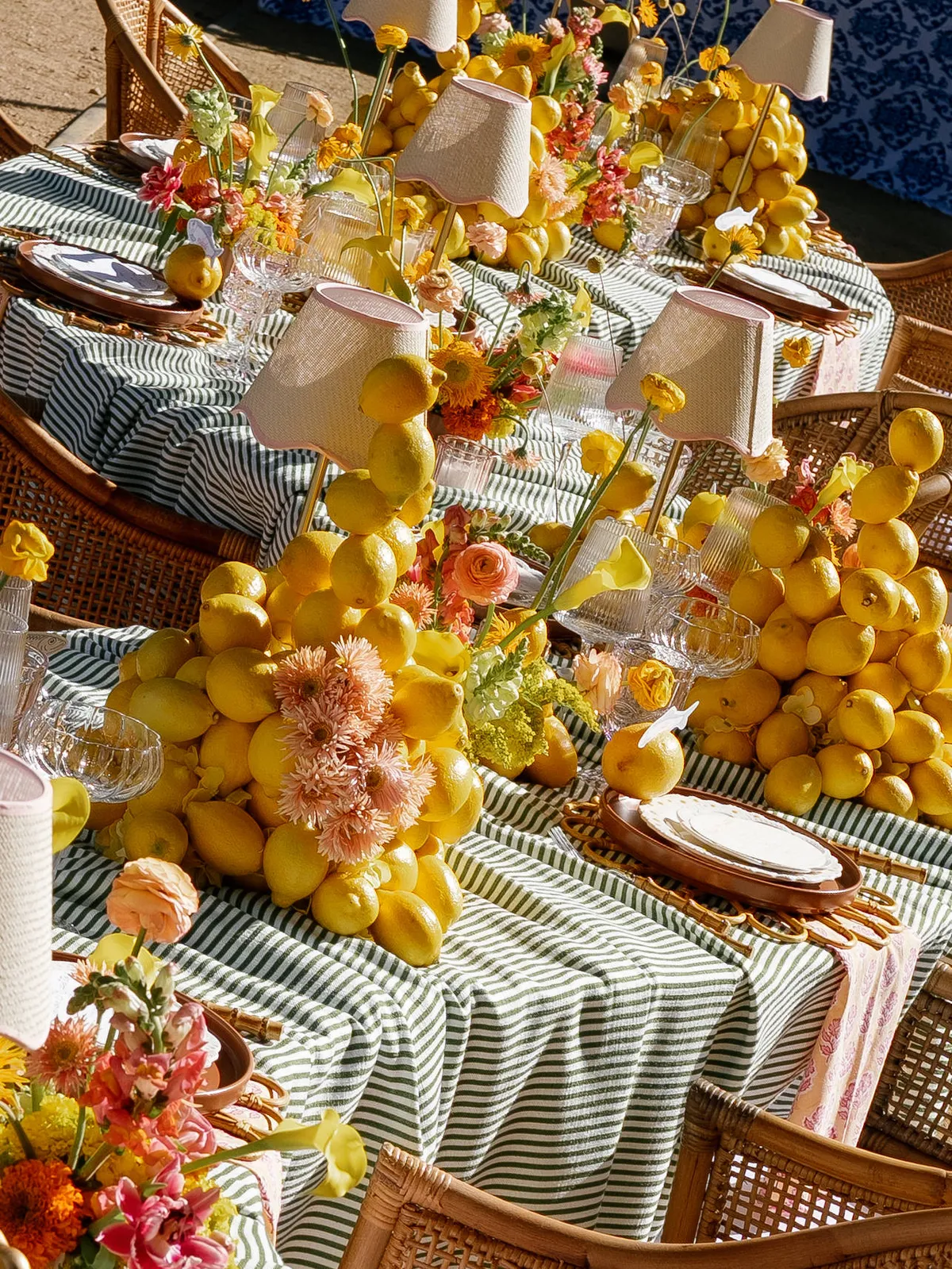 A long wedding table dressed with lemons, garden flowers and green striped linen