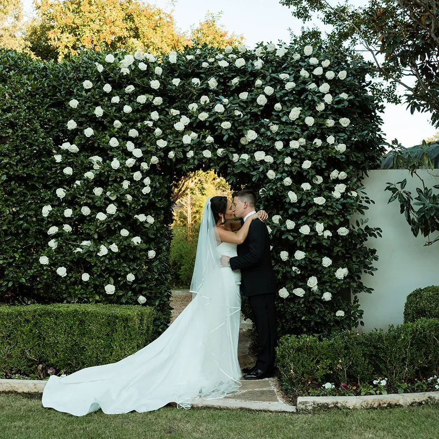 A bride and groom raising a toast beside a reflecting pool