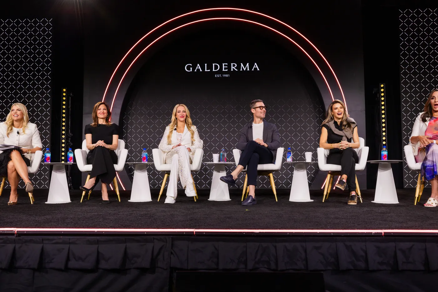 A panel session on a lit main stage at a corporate training program