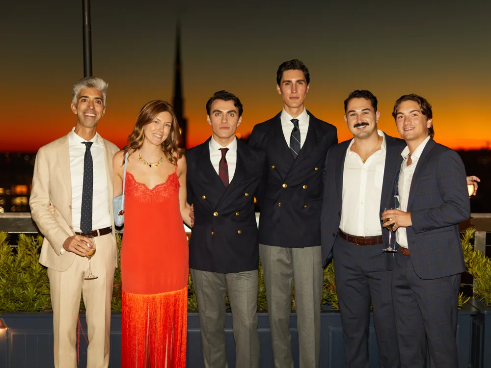 Guests at a rooftop celebration at sunset